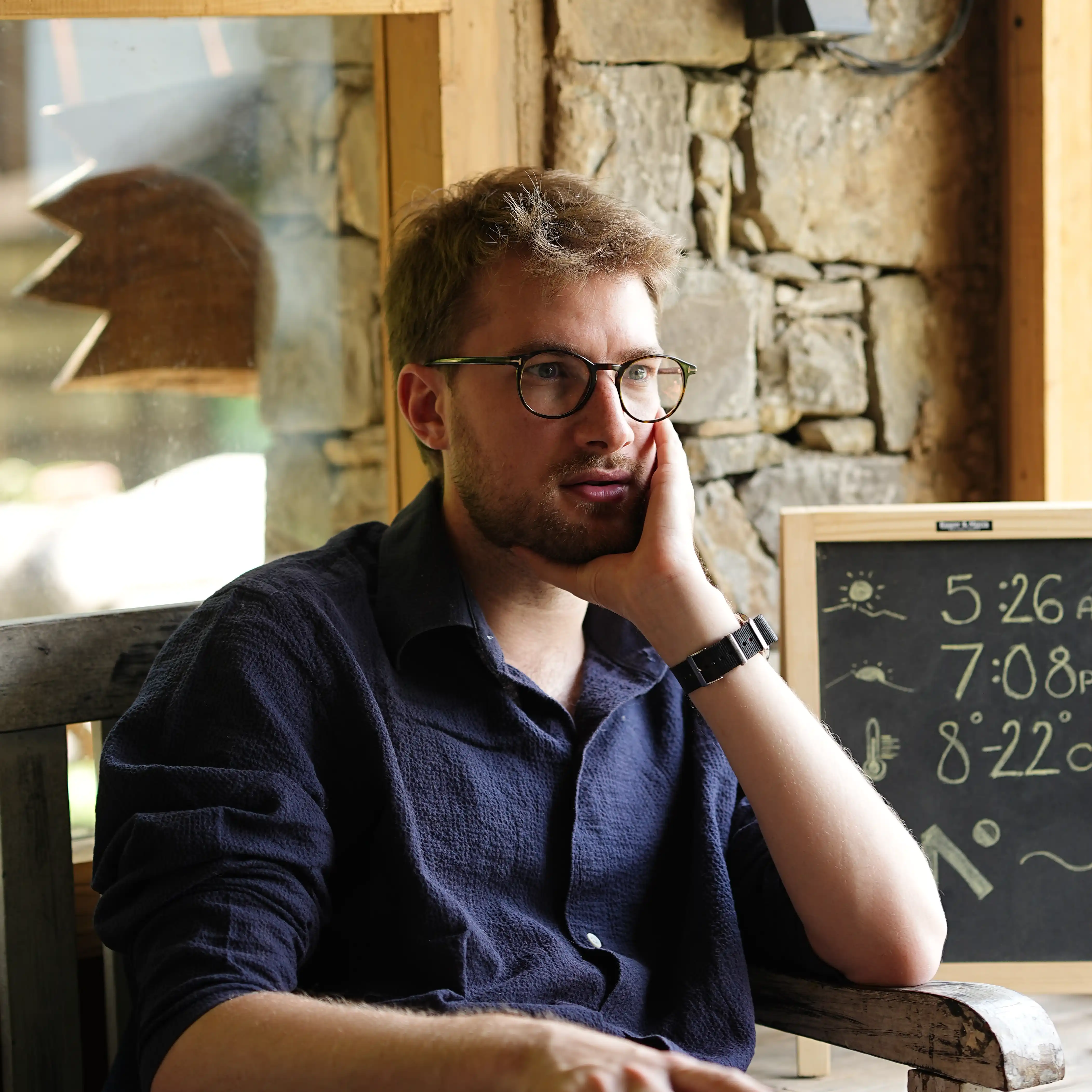 Henry sitting within a stone room.